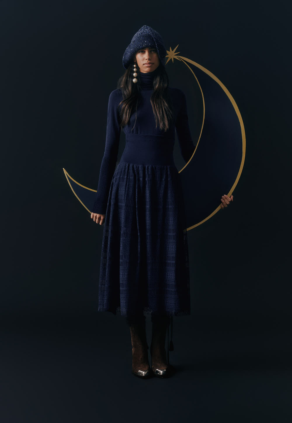 Navy turtleneck sweater styled with textured skirt and knit hat, full look