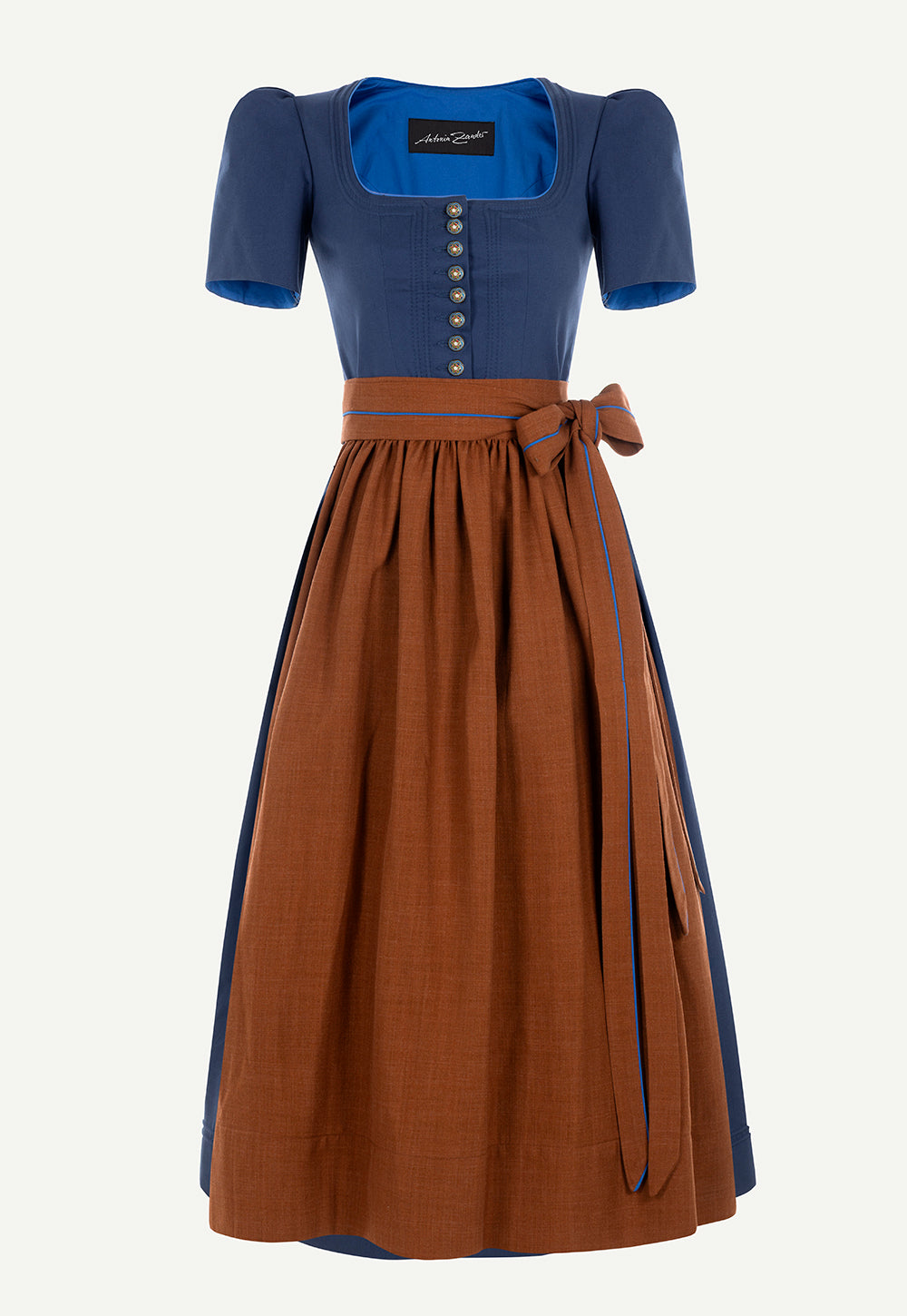 Antonia Zander Judith Dirndl in Pikee Enzian with decorative buttons, a cinnamon brown apron and a fitted silhouette.