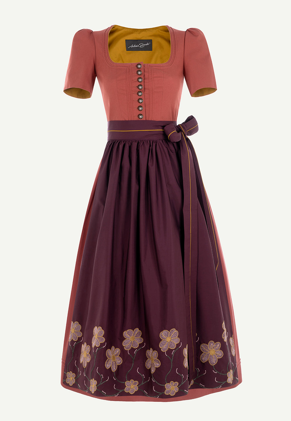 Antonia Zander Judith Dirndl in Pikee Rosewood with hand-painted floral buttons, an embroidered plum apron and a fitted silhouette.